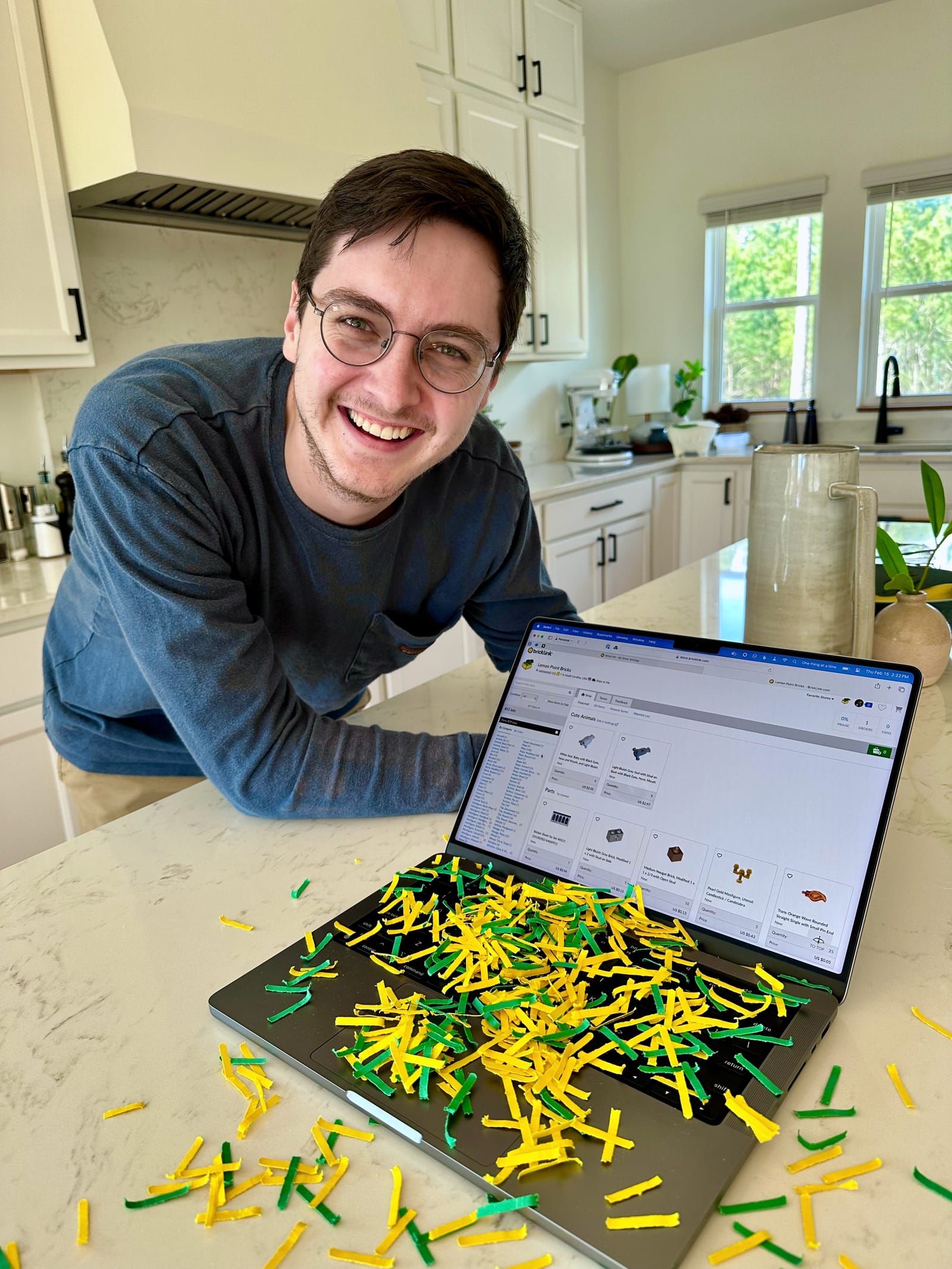 Man posing with laptop covered in yellow and green confetti showing BrickLink store